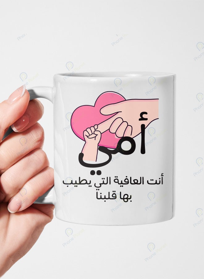 كوب من السيراميك مطبوع عليه عبارة أمي أنتي العافية التي يطيب بها قلبنا ويتميز بمقبض مريح