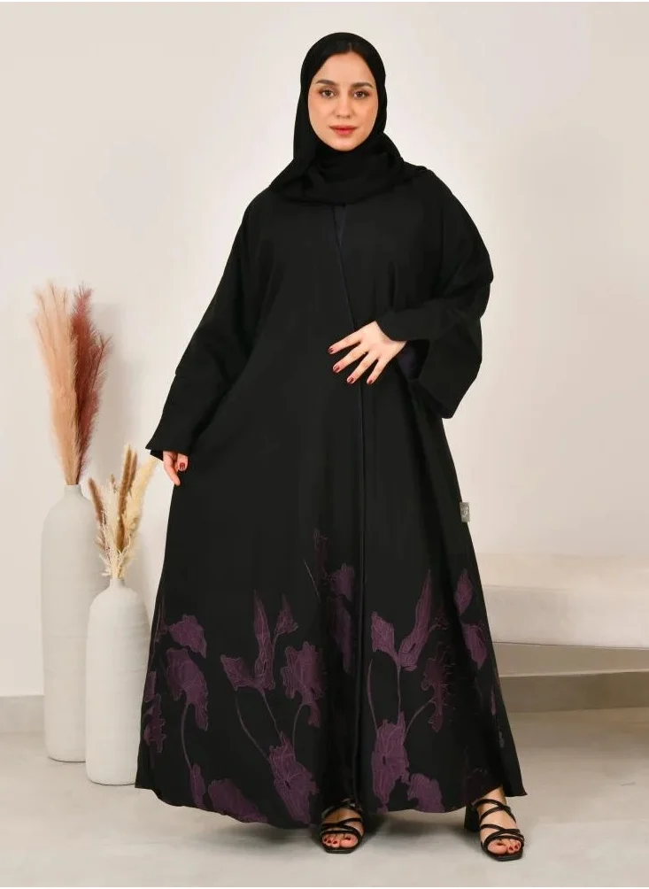 lamha abaya Black cloche abaya with prominent purple embroidery at the bottom of the abaya