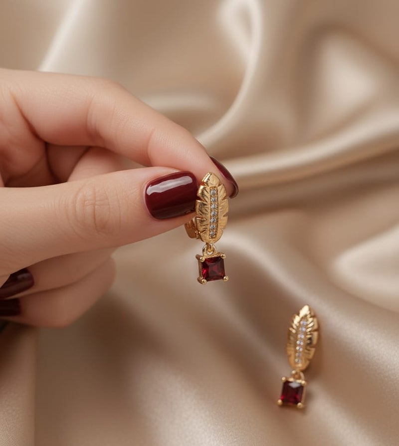 A delicate gold-plated hoop featuring an elegant feather design and sparkling zircon stones, from which hangs a shiny red square zircon piece. - Image 5