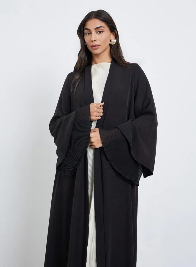 أميرة عباية بأكمام واسعة وتفاصيل بليسيه