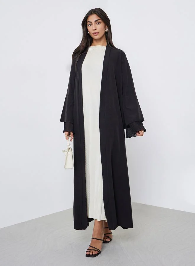 أميرة عباية بأكمام واسعة وتفاصيل بليسيه