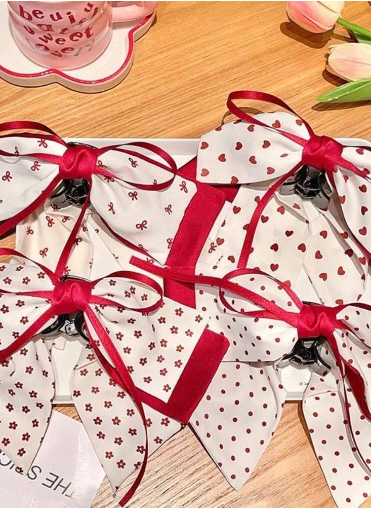 Generic - Add a touch of femininity and sophistication to your look with this hair bow. Designed with a double bow, this combination of white fabric is embellished with a heart and red dot pattern, finished with red satin trim for a stunning finish. The bow comes with a sturdy clip that secures the hair in place, perfect for anniversaries or special occasions. - Image 1