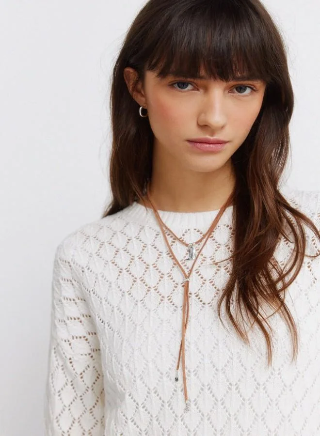 Springfield  Voluminous long sleeve jumper. Round neck. Pointelle knit with openwork details. Ribbed neck. Wavy hem and cuffs. This garment is made with sustainable cotton. for Women | Best Price UAE