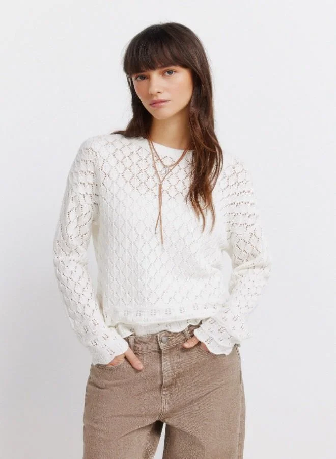 Voluminous long sleeve jumper. Round neck. Pointelle knit with openwork details. Ribbed neck. Wavy hem and cuffs. This garment is made with sustainable cotton.