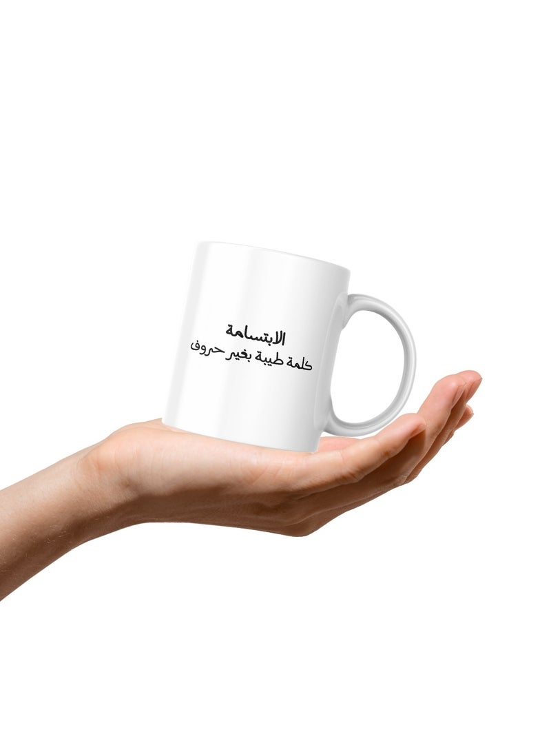 كوب سيراميك جميل مطبوع عليه عبارة "الابتسامة كلمة طيبة بغير حروف" على جانب، و "ابتسم" على الجانب الآخر. هدية أنيقة ومميزة تناسب جميع المناسبات والأشخاص - Image 4