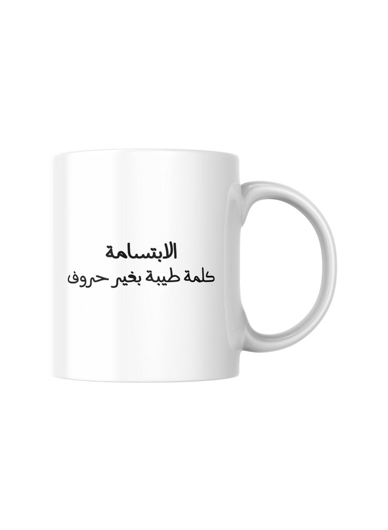 كوب سيراميك جميل مطبوع عليه عبارة "الابتسامة كلمة طيبة بغير حروف" على جانب، و "ابتسم" على الجانب الآخر. هدية أنيقة ومميزة تناسب جميع المناسبات والأشخاص - Image 2