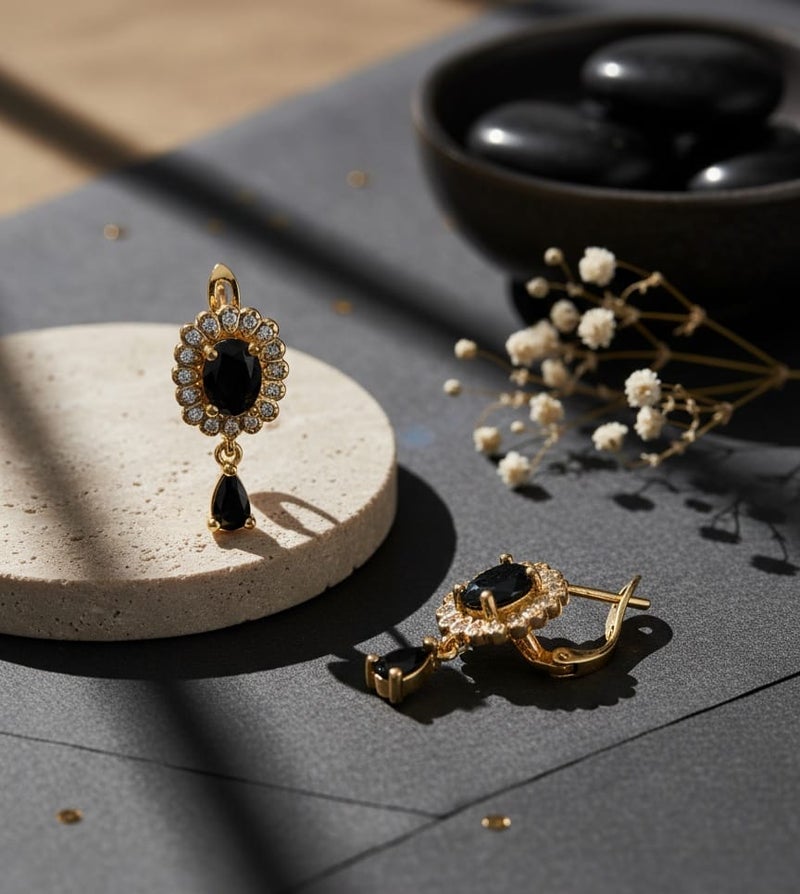 A delicate gold-plated earring featuring a golden flower design studded with shiny stones, a luxurious black stone in the middle, and a luxurious black teardrop stone hanging from it. - Image 4