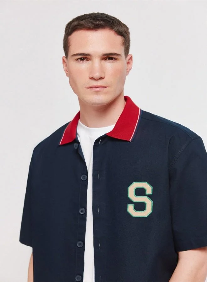 Springfield  1% cotton oxford boxy fit short sleeve shirt with a ribbed polo collar with stripes, letter patches with embroidery on the back and chest, and a tonal button. for Men | Best Price UAE