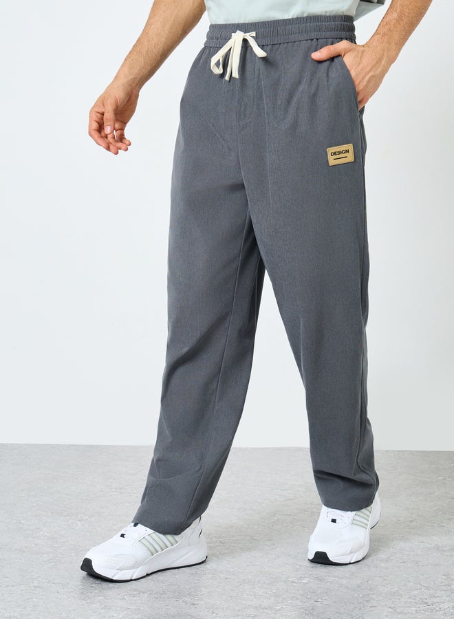 ستايلي بنطلون جوجر ستايلي بقصة مريحة وفتحة سفلية مع تفاصيل شارة وحبل سحب متباين - Image 1