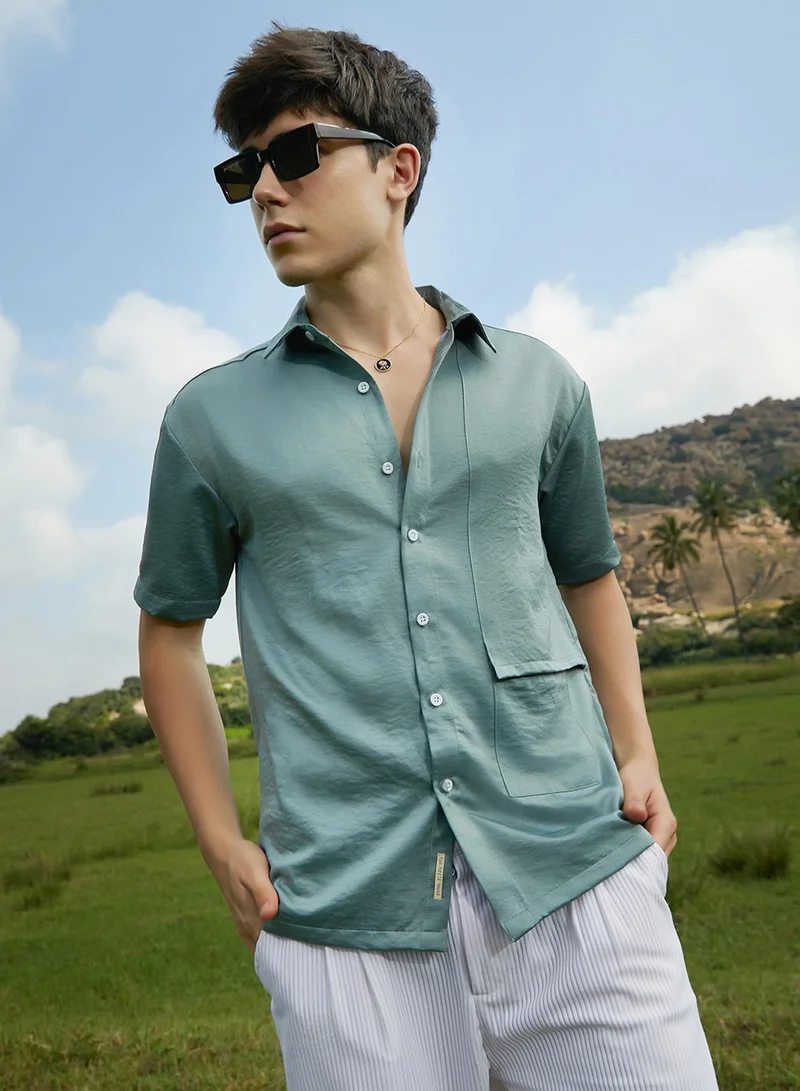 Campus Sutra Campus Sutra Men's Sage Green Solid Flap Oversized Shirt For Casual Wear | Spread Collar | Short Regular Sleeves | Button Closure | Oversized Shirt Crafted With Comfort Fit For Everyday Wear