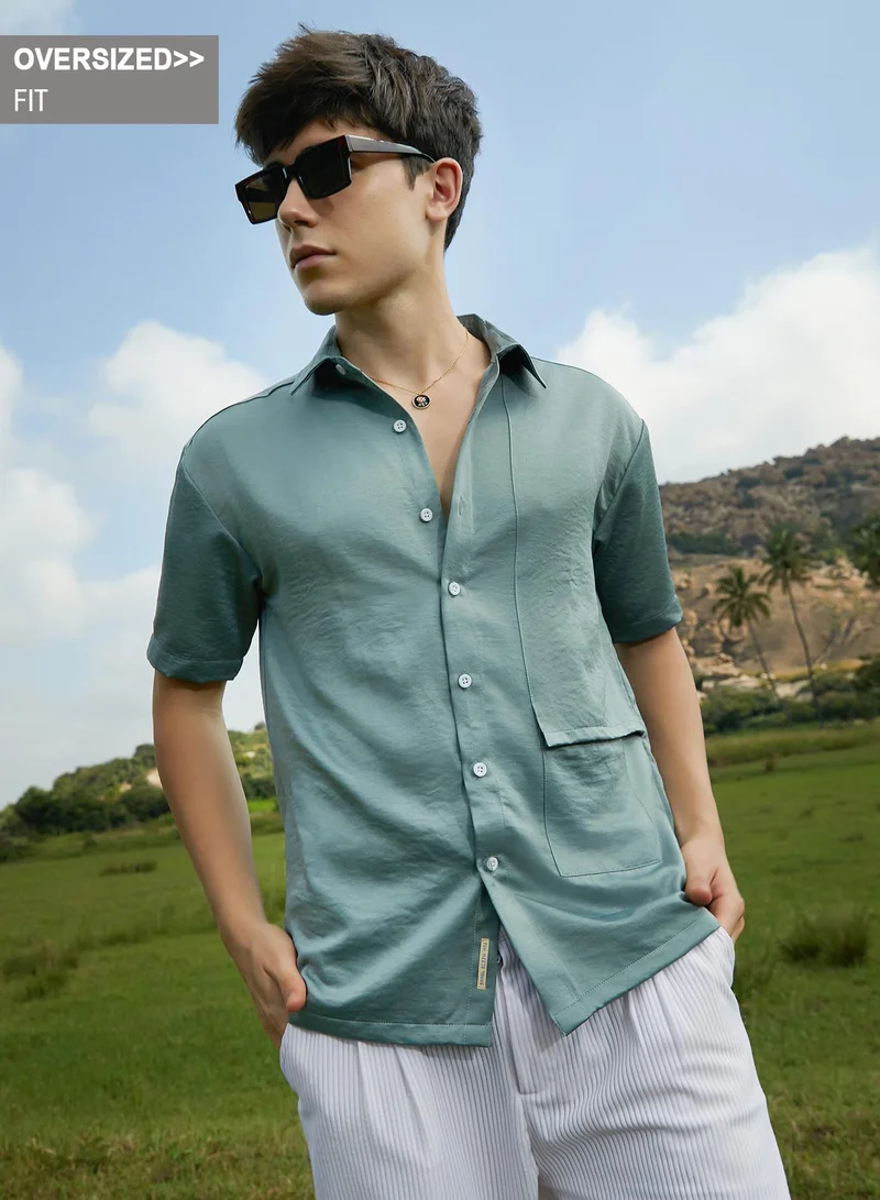 Campus Sutra Campus Sutra Men's Sage Green Solid Flap Oversized Shirt For Casual Wear | Spread Collar | Short Regular Sleeves | Button Closure | Oversized Shirt Crafted With Comfort Fit For Everyday Wear