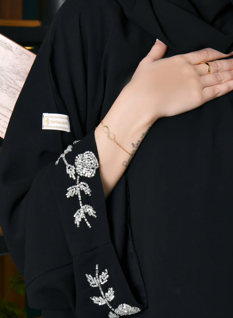 HAWRAA ABAYA Black cloche wrap abaya decorated with an elegant white and pink check