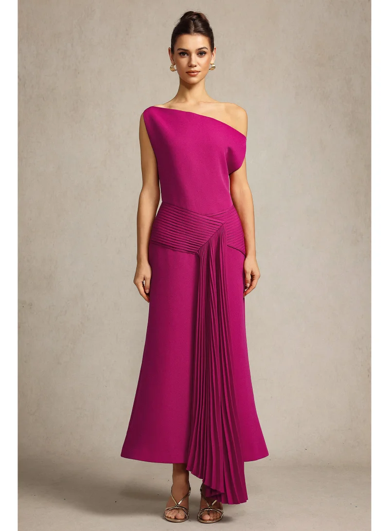 بيلا بارنيت فستان ميدي بولينيا بدون أكمام بكتف مائل وثنيات باللون الوردي الفاتح.