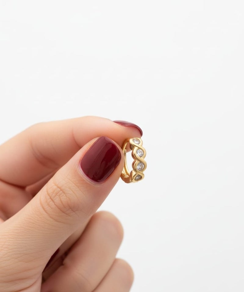 A delicate gold-plated hoop featuring a wavy wrap design, studded with sparkling stones. - Image 4