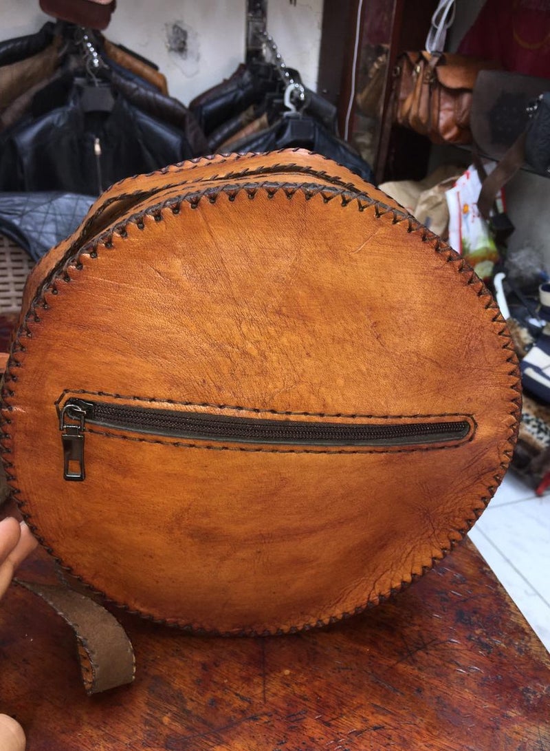 Medium-sized round bag made of natural leather, hand-made closure A suitable belt handle to adjust its length 2 zippers Lined with velvet from the inside Close with shiny thread  - Image 3