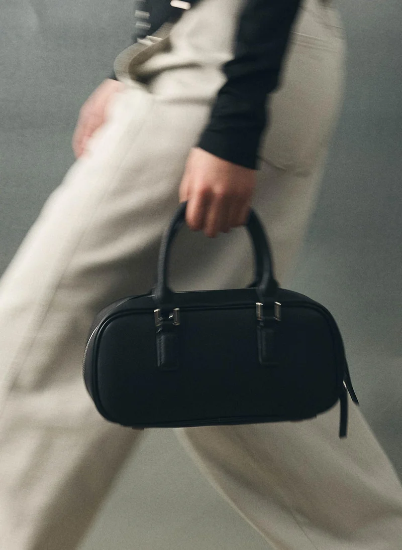 Rigid-shaped bag with short handles and a strap