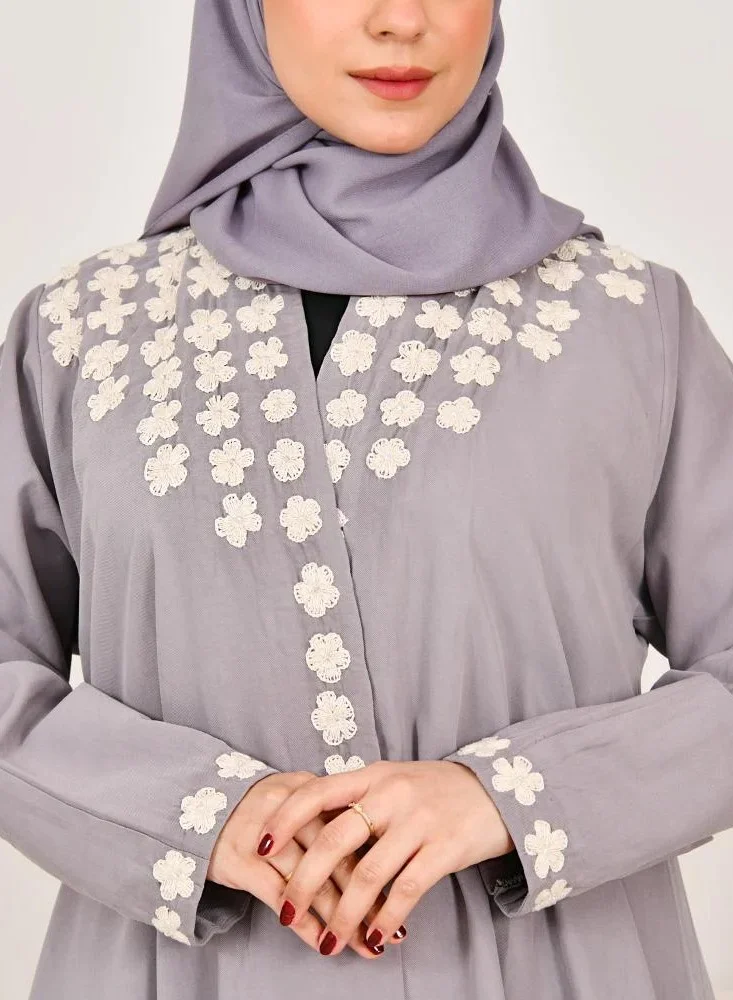lamha abaya Elegant quarter-cloche abaya in light gray with prominent white embroidery on the sides of the abaya and sleeves