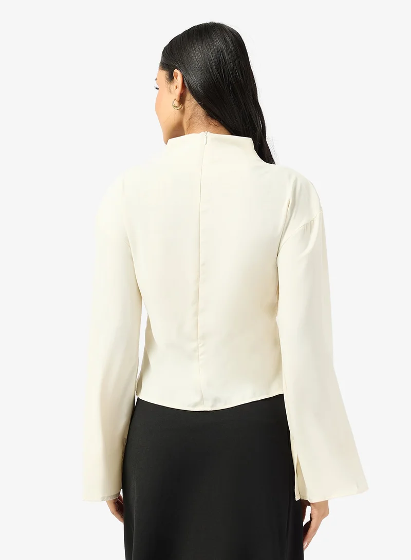 جينجر بلوزة بياقة عالية وتفاصيل مكشكشة