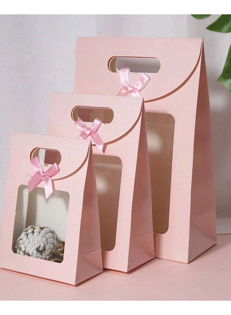 3 different sized pink cardboard bags with a clear window and a pink bow, perfect for gift giving and all occasions. - Image 1