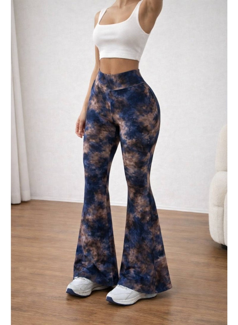 Women's pants with a high waist and a wide cut at the bottom, featuring a modern tie-dye pattern in blue and brown colors. Made from comfortable stretchy fabric suitable for everyday and casual looks. It is styled with a white sleeveless crop top for a chic and trendy look. White sneakers add a youthful and practical touch. Suitable for wearing at home or going out with friends. - Image 1
