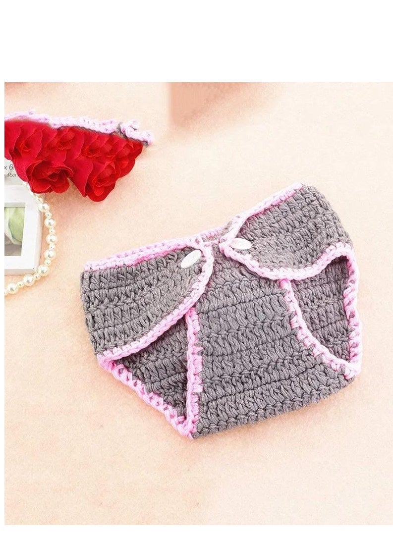 A crocheted baby boy consisting of a small hat with a bunny ears design decorated with a prominent rose, in addition to another piece used as a cover or comfortable clothing that is closed with buttons. The basic color of the set is light gray with pink edges, giving it an elegant and soft look suitable for children.