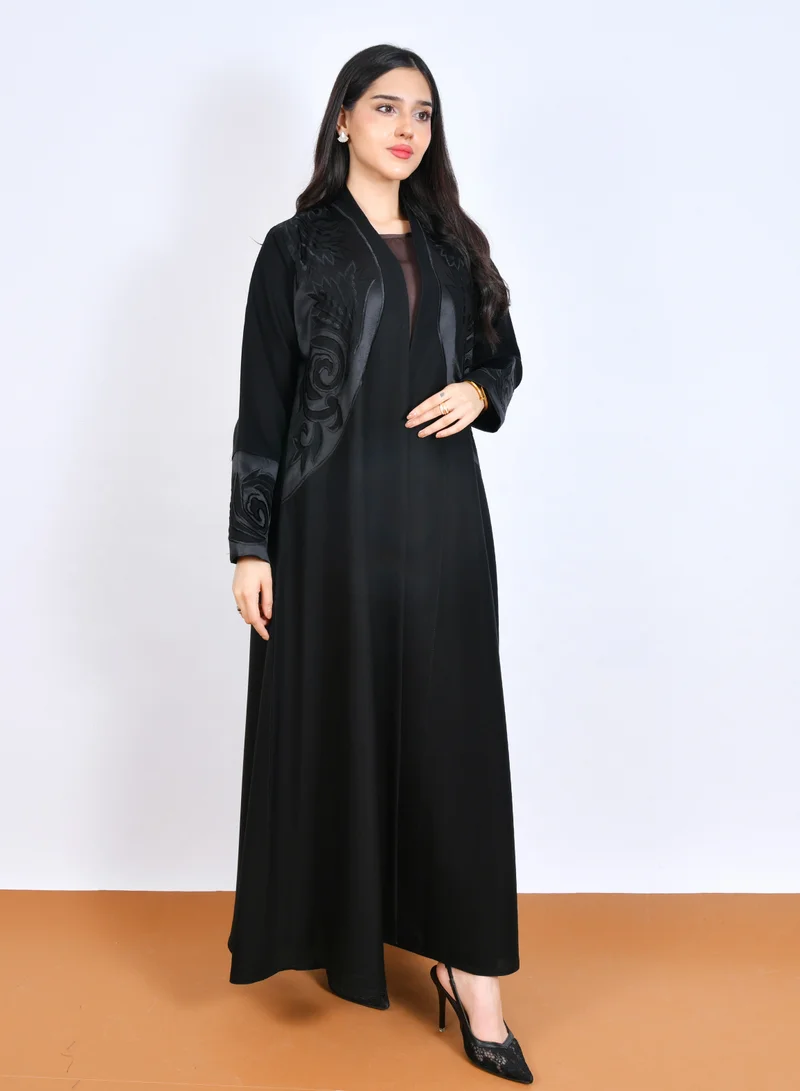 HAWRAA ABAYA Classic Black Abaya adorned with elegant raised embroidery on the chest and sleeves, designed in a half-cloche cut with soft, flowy fabric.