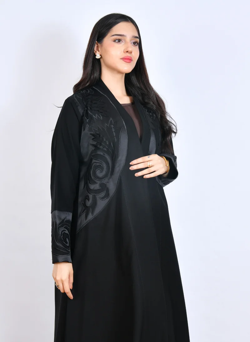 HAWRAA ABAYA Classic Black Abaya adorned with elegant raised embroidery on the chest and sleeves, designed in a half-cloche cut with soft, flowy fabric.