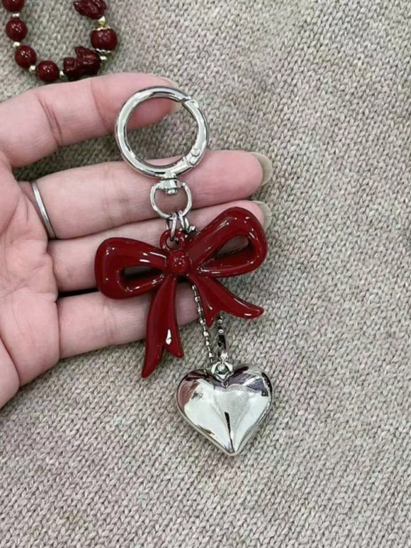 ميدالية مفاتيح بتصميم فيونكة حمراء وقلب فضي – اكسسوار أنيق للحقائب والمفاتيح - Image 1