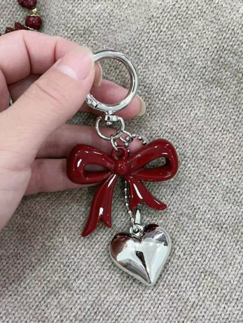 ميدالية مفاتيح بتصميم فيونكة حمراء وقلب فضي – اكسسوار أنيق للحقائب والمفاتيح - Image 2
