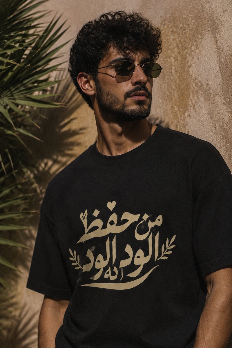 تي شيرت رجالي أسود بطبعة خط عربي وقصة واسعة تصميم كاجوال عصري بأكمام قصيرة وياقة دائرية - Image 1