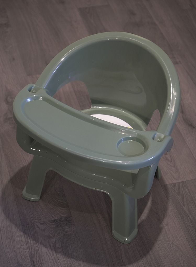 A plastic chair for children with a food holder and a place for cups