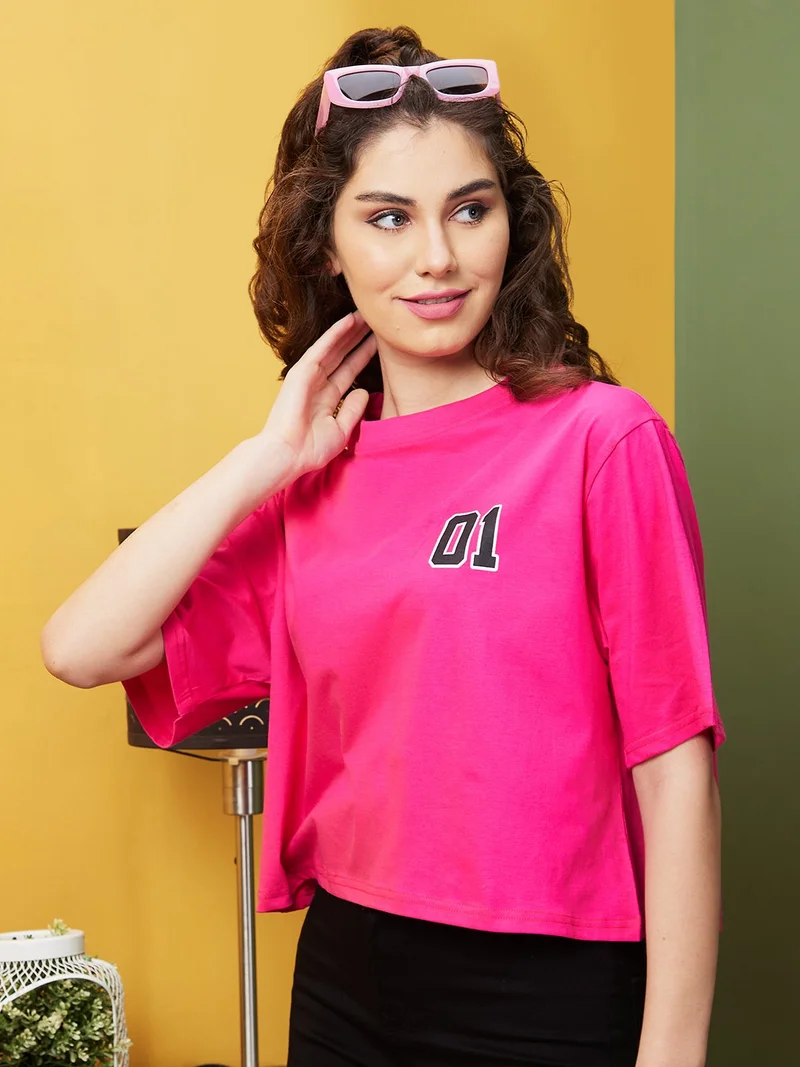 جلو باص تيشيرت قطن نقي بقصة واسعة وطباعة وردية بحروف نسائية