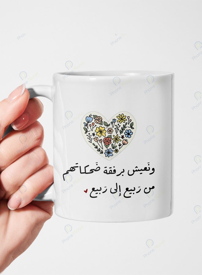 A mug printed with the phrase And we live with their laughter from spring to spring featuring a distinctive design for tea and coffee and a comfortable multicolored handle