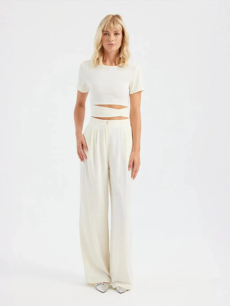 زوبعة قطعتان: بلوزة قصيرة بياقة مستديرة ورباط خلفي مع بنطلون واسع مطوي بخصر عالٍ
