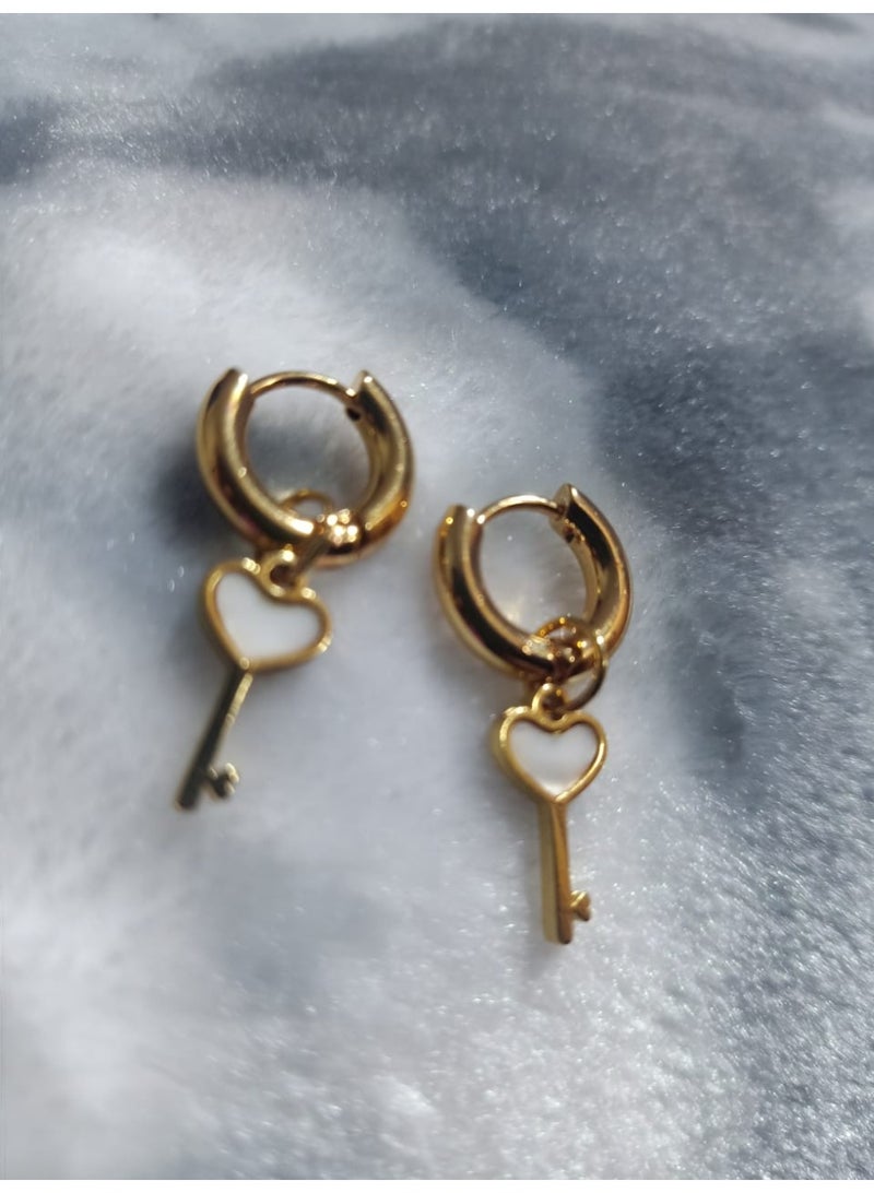 Luxuria Gold-plated hoop earrings with a key design adorned with a white heart. These earrings are also known as "heart key earrings". - Image 1