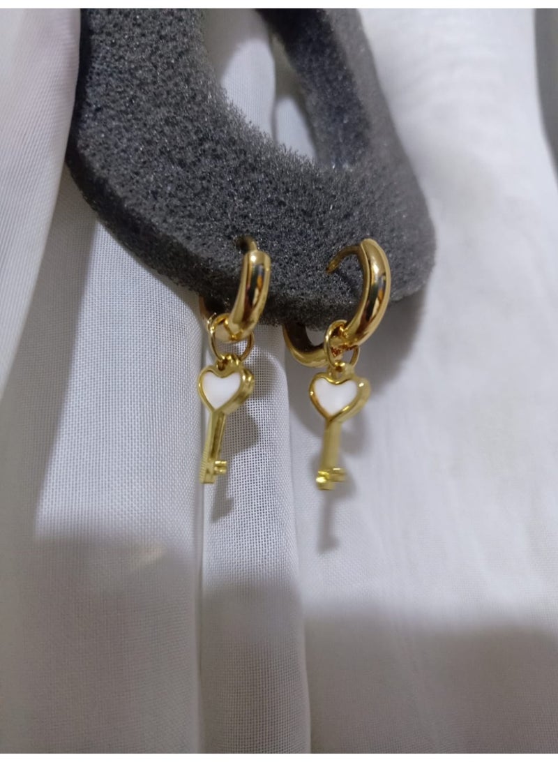Luxuria Gold-plated hoop earrings with a key design adorned with a white heart. These earrings are also known as "heart key earrings". - Image 3