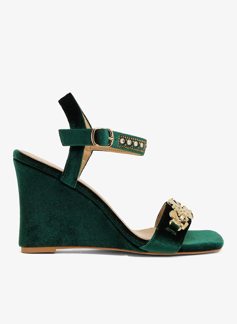 Emerald green wedge sandal with gold floral embellishment and ankle strap