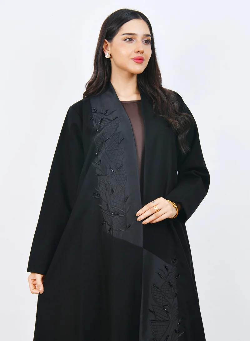 عبايات حوراء عباية سوداء أنيقة بتصميم فاخر بقَصّة نص كلوش مع تطريز بارز على الواجهة يضفي لمسة راقية وعصرية