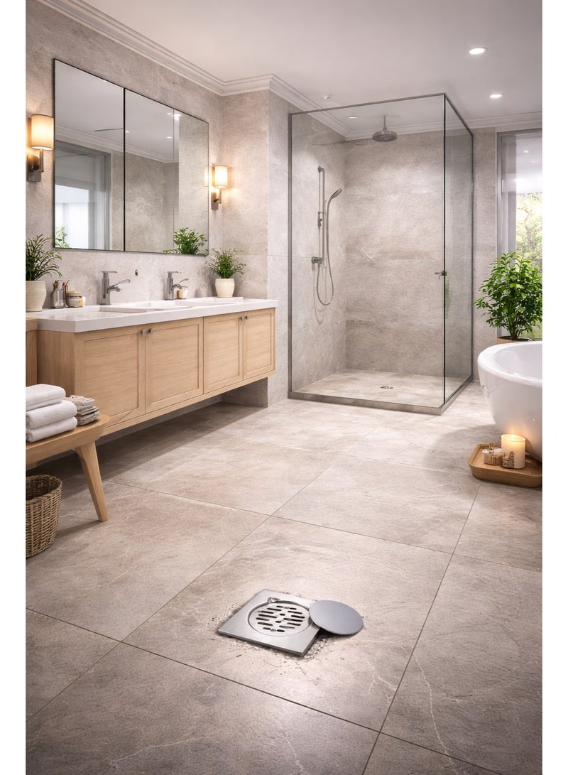 bavly A floor drain made of stainless steel, installed on a light grey travertine surface. The drain features an elegant and durable design with a removable round metal cover, efficiently draining water. The naturally lit outdoor setting near the swimming pool adds a touch of modern elegance and functionality, making it ideal for areas that require effective and stylish drainage solutions - Image 2