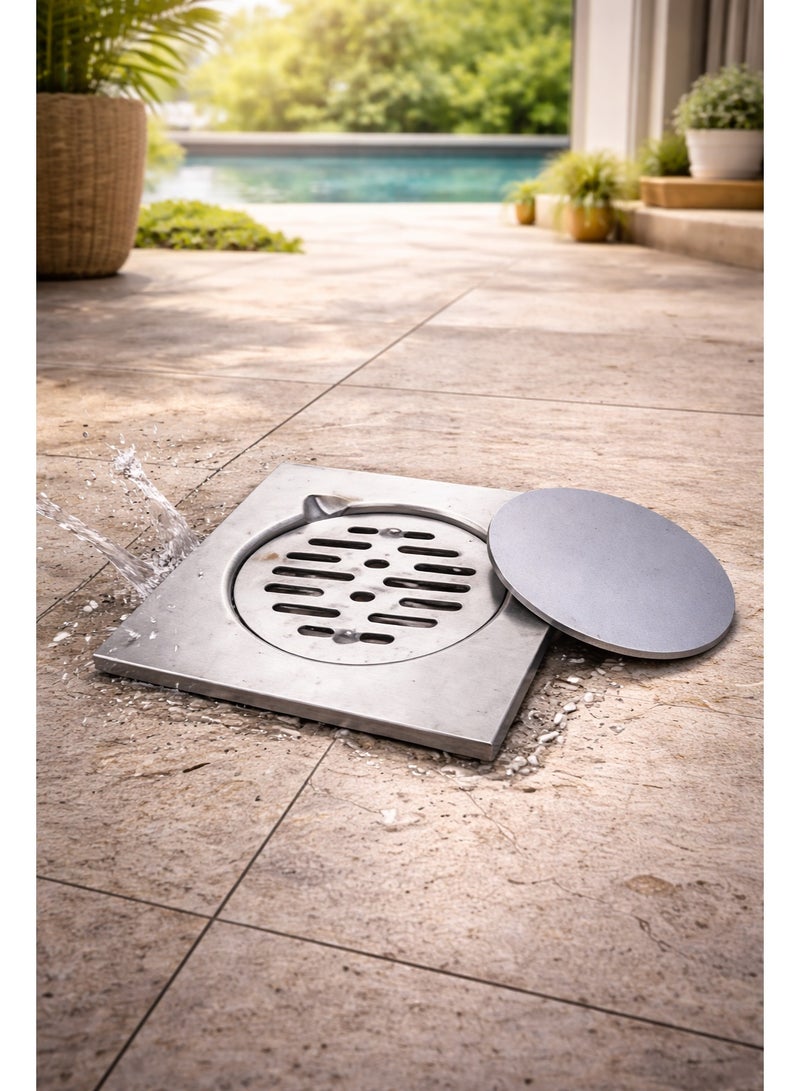 bavly A floor drain made of stainless steel, installed on a light grey travertine surface. The drain features an elegant and durable design with a removable round metal cover, efficiently draining water. The naturally lit outdoor setting near the swimming pool adds a touch of modern elegance and functionality, making it ideal for areas that require effective and stylish drainage solutions - Image 3