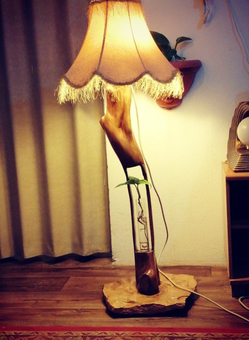 A lamp with a natural tree trunk carved in the middle to hold a glass vase mounted on a piece of natural stone coated with resin. - Image 1