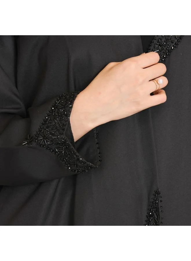 HAWRAA ABAYA Black abaya with a distinctive cut on the sides, decorated with prominent black embroidery