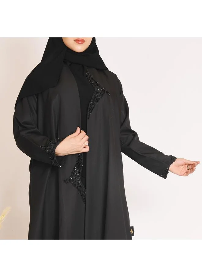 HAWRAA ABAYA Black abaya with a distinctive cut on the sides, decorated with prominent black embroidery