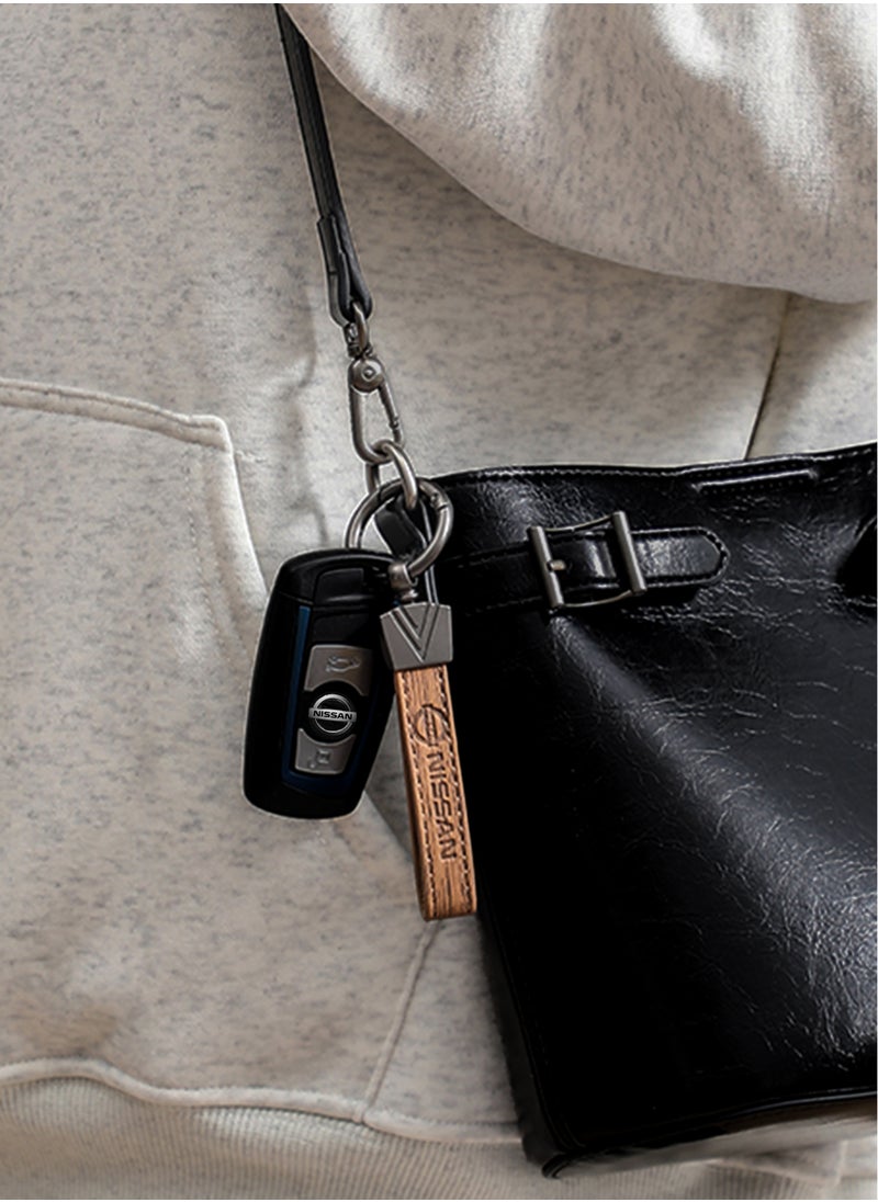 Elegant light brown metal and leather keychain with NISSAN logo featuring 3 key rings perfect as a fancy gift or car accessory designed in sleek light brown for a modern look offers 360 degree rotation for convenience suitable for both men and women and comes in a gift box.