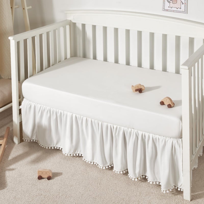 TILLYOU تنورة سرير الأطفال TILLYOU للبنات والأولاد، تنورة سرير مزخرفة مع كرات، 28 بوصة × 52 بوصة، 14 بوصة انخفاض، أبيض - Image 1