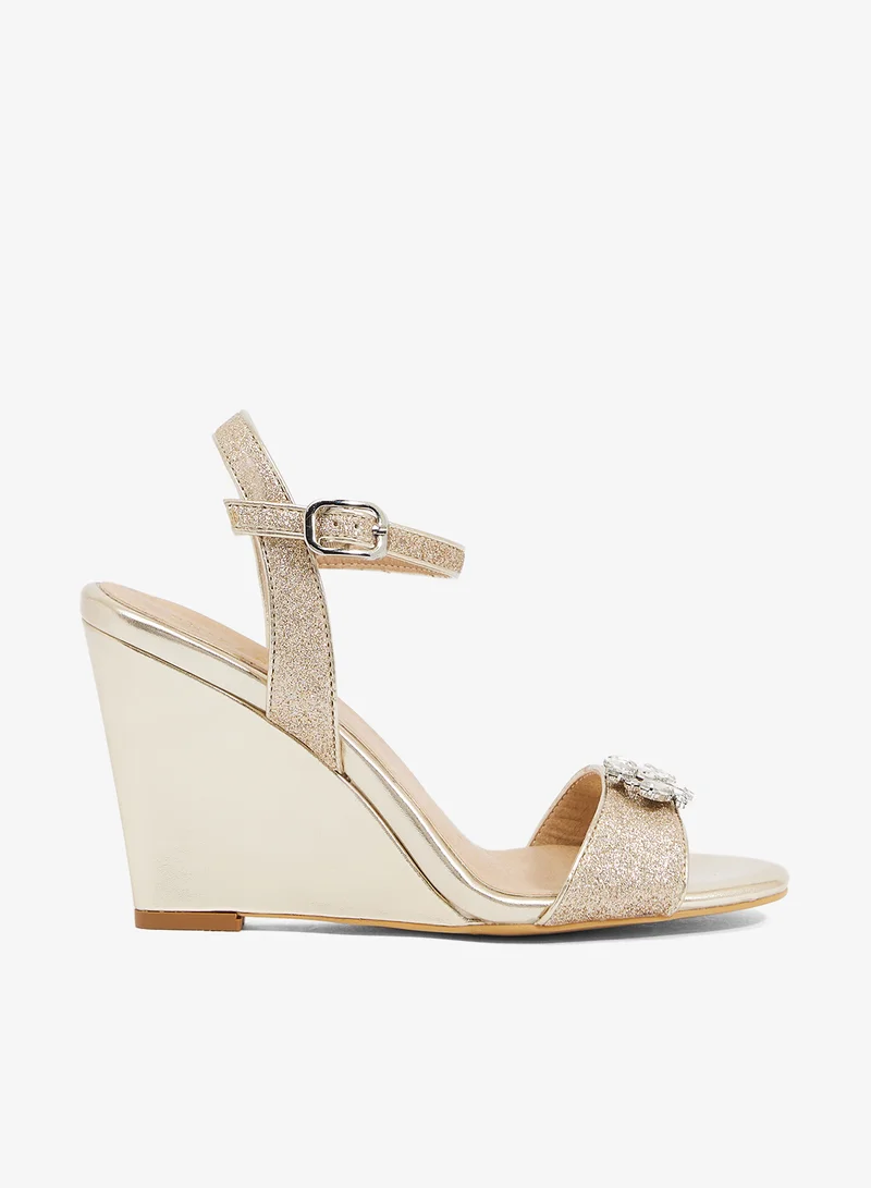 Gold wedge sandal with glitter straps and crystal brooch