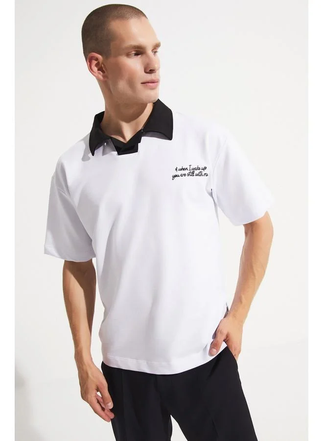 جون تيشيرت رجالي أبيض مطرز بتفاصيل ياقة على شكل حرف  بتصميم واسع من يونيو