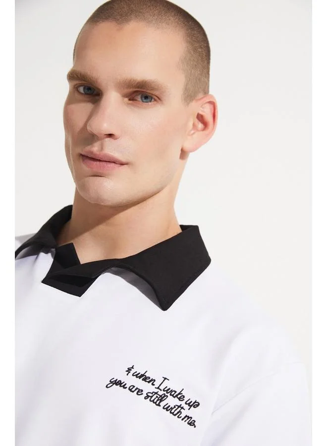 جون تيشيرت رجالي أبيض مطرز بتفاصيل ياقة على شكل حرف  بتصميم واسع من يونيو