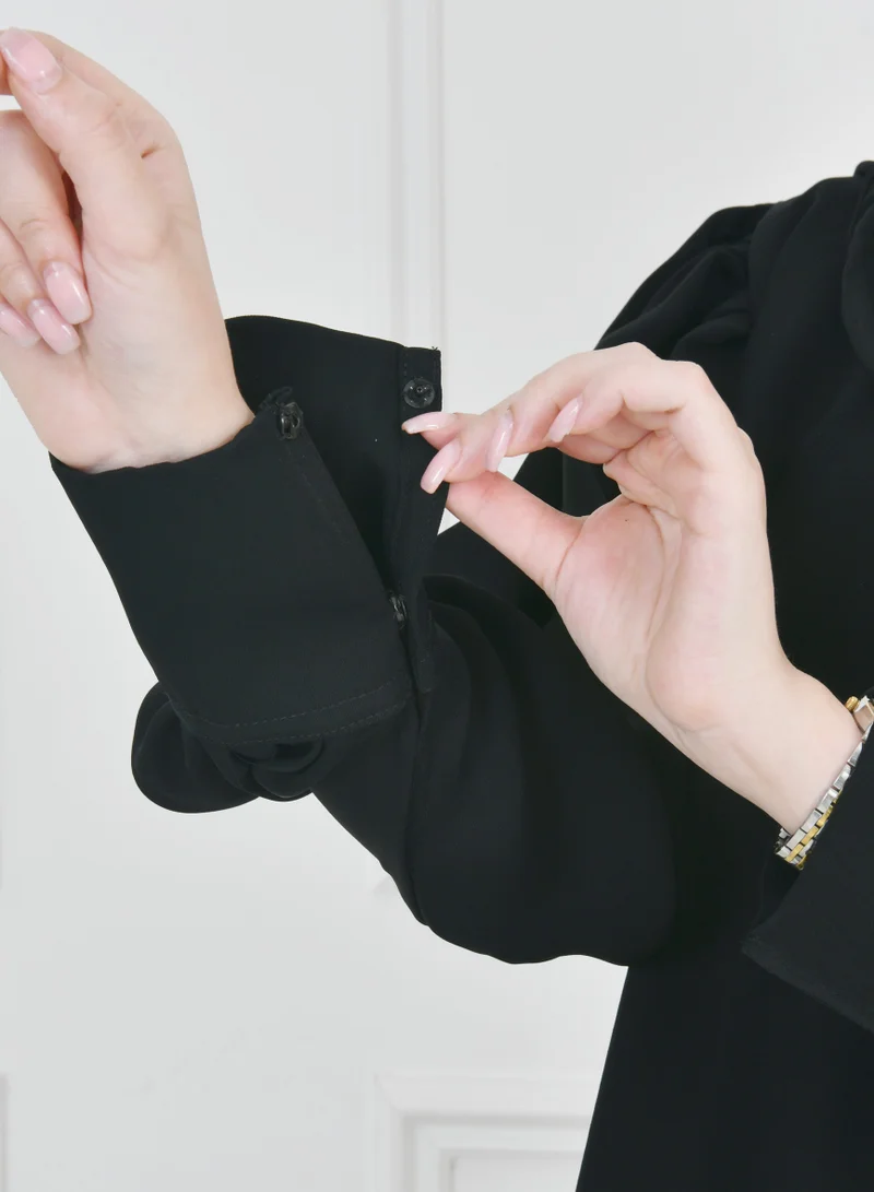 HAWRAA ABAYA Black quarter-length abaya with narrow, practical sleeves that close with snaps
