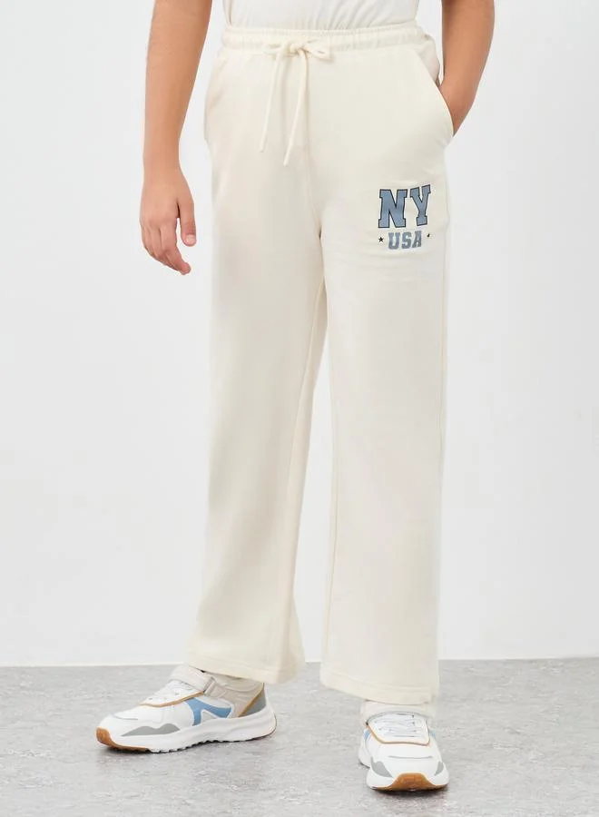 Styli Styli Girls Off White Slogan Print Oversized T-Shirt and Wide Leg Joggers Set